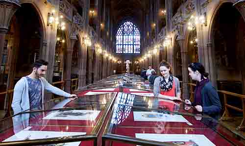 Students looking at display cases in the John Rylands Library